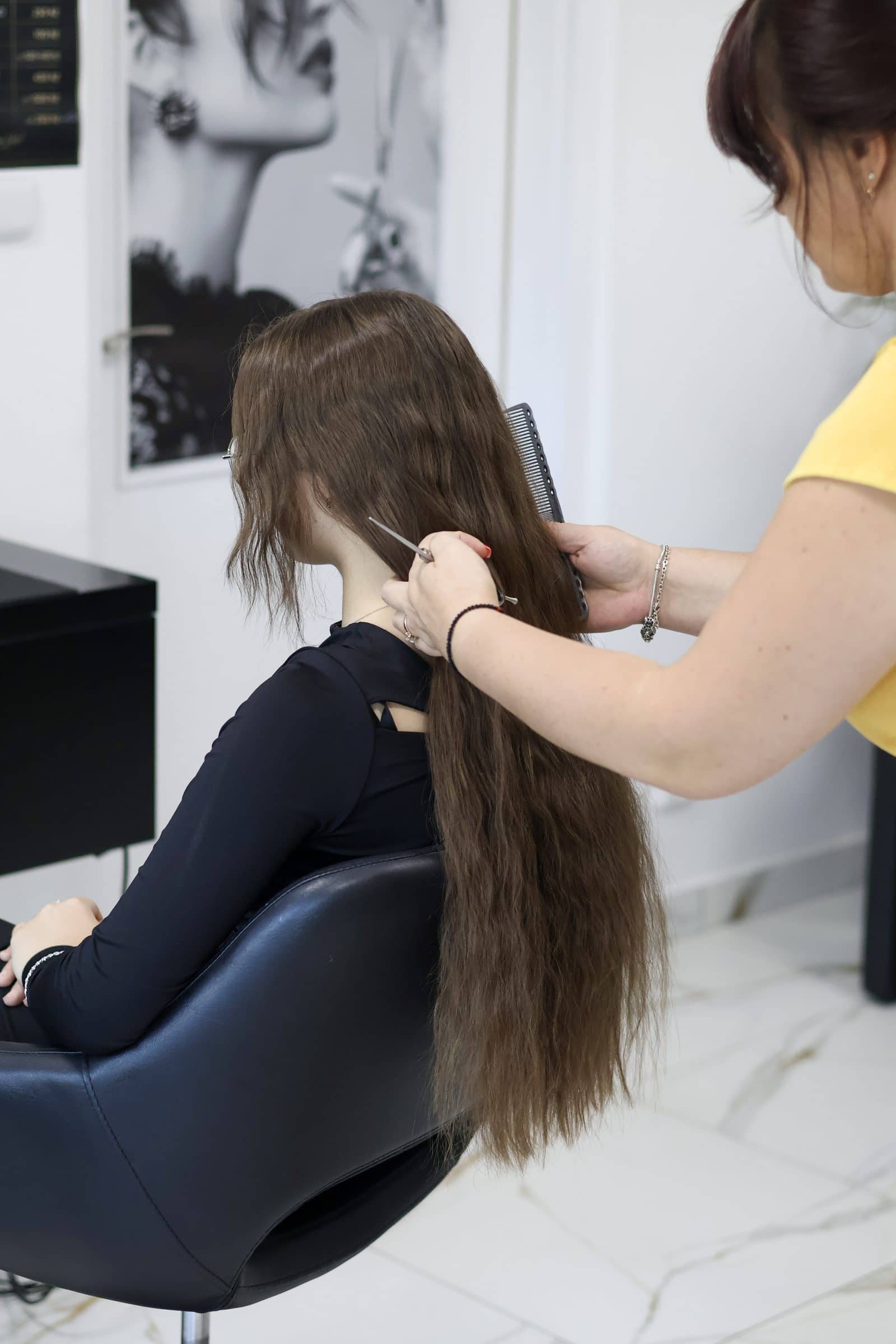 Natalia češe dlouhé vlasy zákaznice u křesla